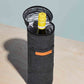Insulated black cooler tote with opened top holding a chilled bottle of white wine on a light surface