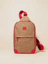 Compact tan sling bag with red straps and accents, designed for easy adjustment and secure, hands-free carry.
