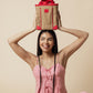 Smiling woman holding Chill Zone Lunch Cooler with red handles and eco-friendly beige fabric above her head.