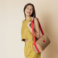 Woman carrying Day Cruiser Lunch Cooler with adjustable red strap and beige insulated lunch bag for fresh food.