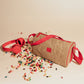 Day Cruiser Lunch Cooler insulated lunch bag with red strap next to red headphones and colorful jellybeans scattered around.