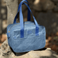 Blue washable paper lunch cooler on a stone