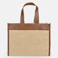 Tote bag with brown leather top section and natural woven bottom section on a white background