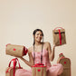 Woman holding and posing with brown and red bags on a beige background