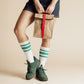 Person holding a Paper Sack Lunch Cooler with a red buckle, styled with casual outfit and green sneakers.
