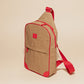 Compact tan sling bag with red accents, adjustable strap, zippered compartments, designed for easy, hands-free carrying.