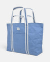 A stylish XL blue and white beach tote with coastal look and dual handles and front pocket